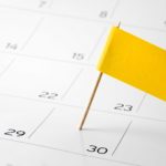 Yellow flag pinned on the calendar on the 30th day of the month